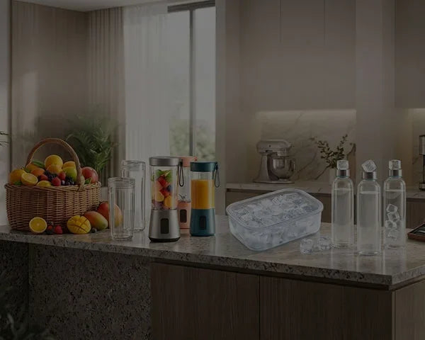 Kitchen countertop with blender, water bottles, fruit basket, and ice container for healthy living
